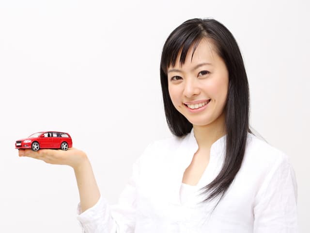 白い服の女性と手の上に車